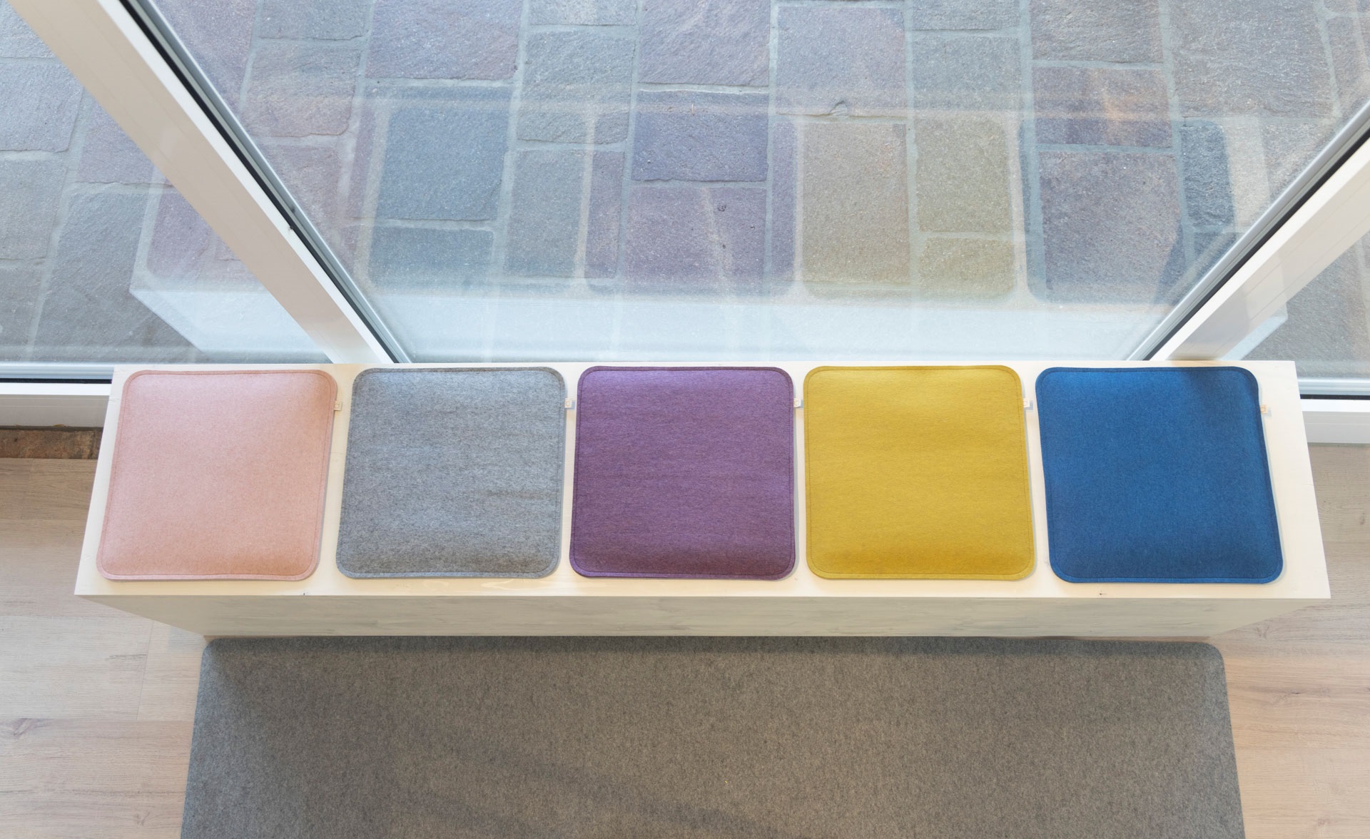 5 disana Filz-Sitzauflagen gepolstert aus Woll-Recycling-Filz (100% Bio-Merinowolle) in Rosé, Grau, Aubergine, Gold und Blau.